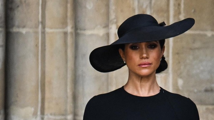Meghan, Duchess of Sussex looks at the coffin of Queen Elizabeth II, draped in a Royal Standard and adorned with the Imperial State Crown and the Sovereign's orb and sceptre, as she leaves Westminster Abbey in London on September 19, 2022, after the State Funeral Service for Britain's Queen Elizabeth II. (Photo by Oli SCARFF / AFP) (Photo by OLI SCARFF/AFP via Getty Images)