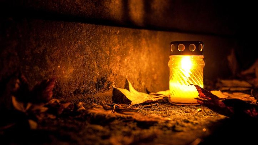 Ilustrasi cahaya di kubur Candle burning with nice yellow colour with leaves all around.