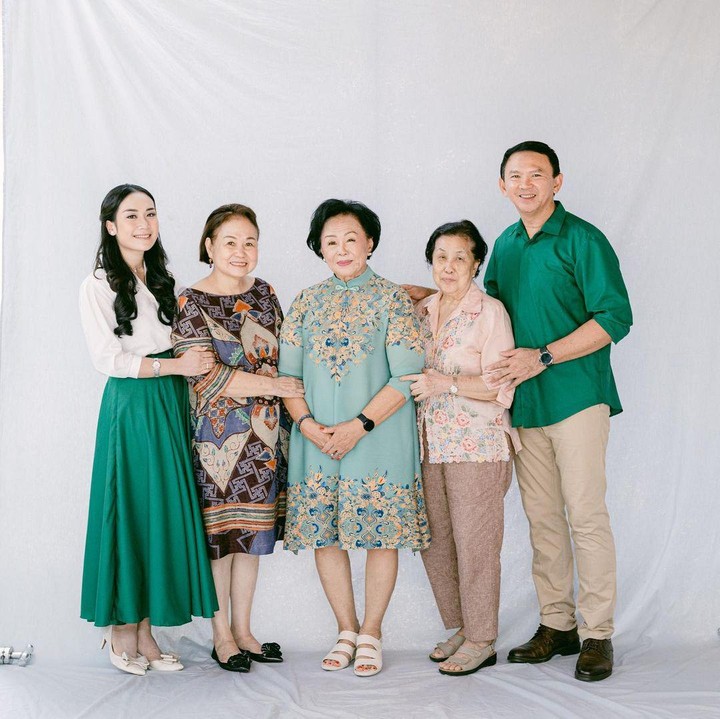 <p>Ketika berfoto bersama mertua, Puput Nastiti Devi tampil memesona dengan memakai <em>flare skirt</em> berwarna hijau yang senada dengan baju Ahok. (Foto: Instagram @btpnd @petitebymono)</p>