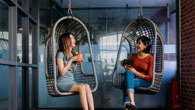 1318776206 Image of two young asian office workers having a discussion during coffee break in office