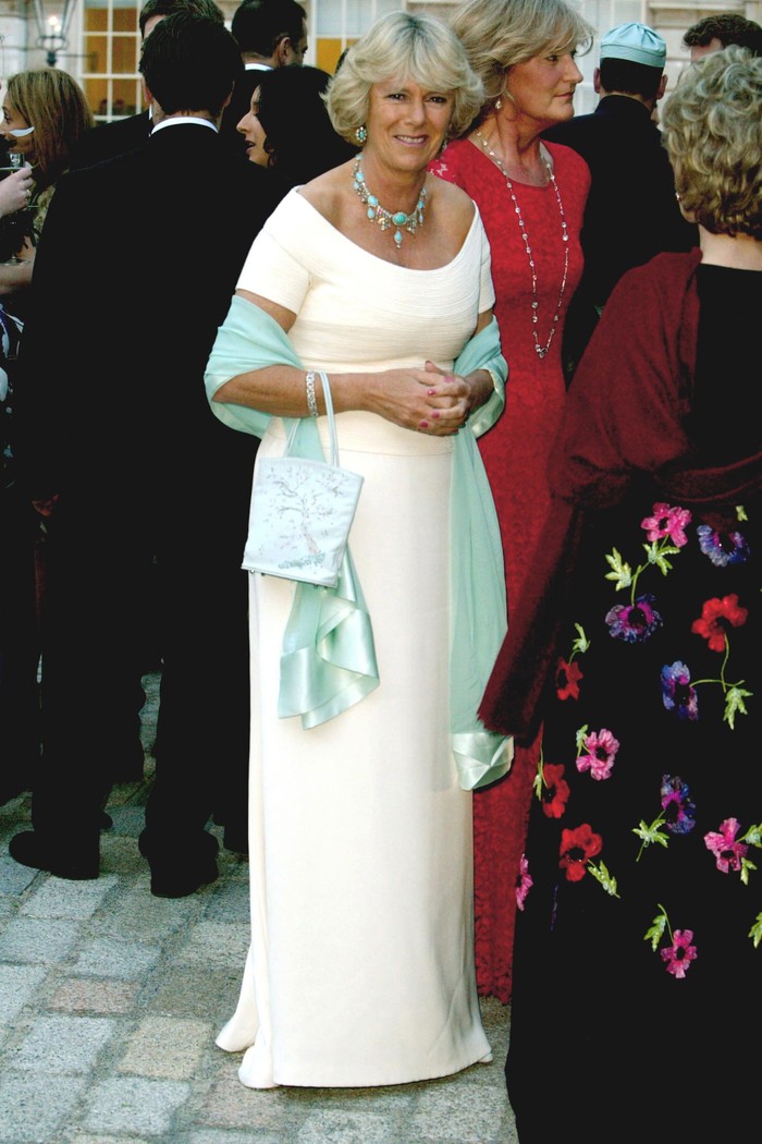 Camilla tampil bold dalam padanan warna tak biasa yakni gaun putih dengan kalung dan selendang warna turqouise pada tahun 2002. Foto: Tim Graham Photo Library via Get/Pool/Tim Graham Picture Library