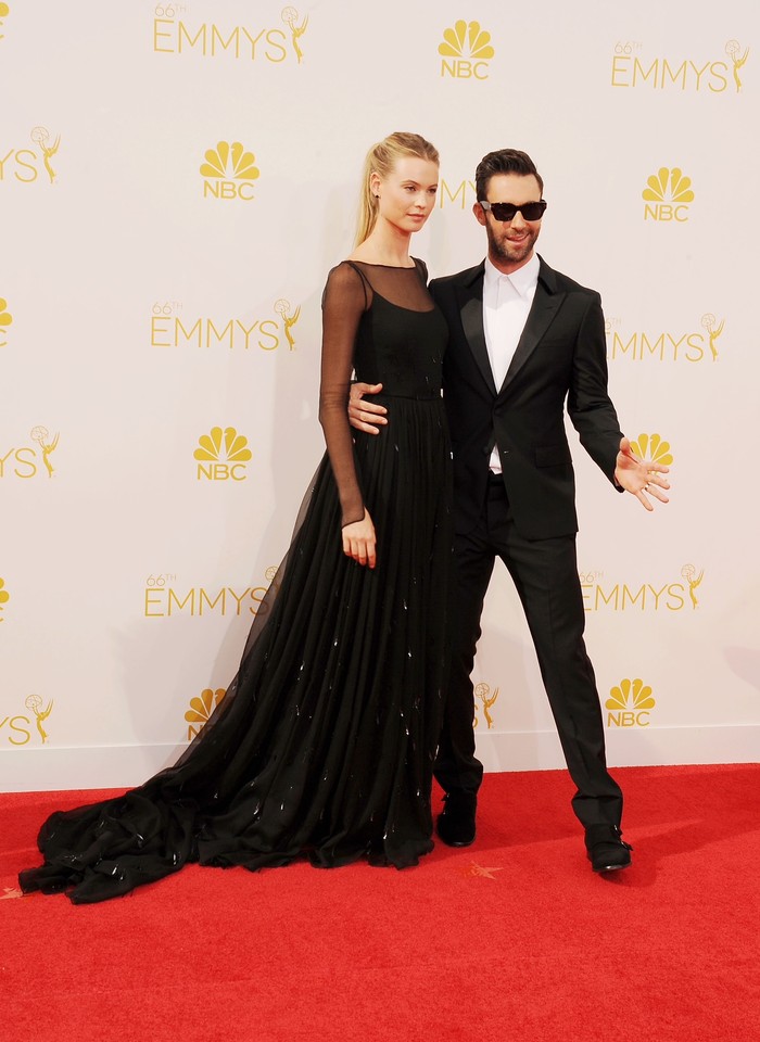 Pada ajang Emmy Awards 2014 keduanya menampilkan gaya glamor yang bernuasna fun. Adam menambahkan sunglasses alih-alih dasi pada setelannya. Sementara Behati terlihat classy memakai gaun hitam lengan panjang kreasi Prada. Foto: Getty Images