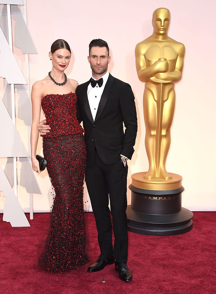 Hadir di Academy Awards 2015, gaya klasik dan elegan ditampilkan pasangan yang menikah pada tahun 2014 ini. Behati tampil stunning memakai gaun strapless merah rancangan Armani Prive dan Adam memilih setelan jas hitam dengan dasi kupu-kupu. Foto: WireImage/Steve Granitz