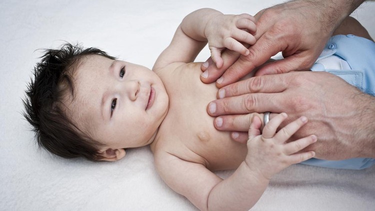 Ilustrasi Hernia Seperti Anak Rizky Billar dan Lesti Father gives his 4 month old son a gentle massage around his chest and stomach area showing nurturing, caring and bonding time with father and baby