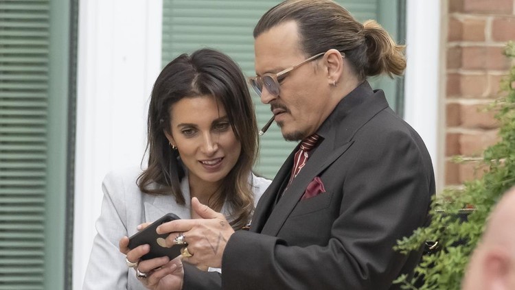 Johnny Depp dan Joelle Rich FAIRFAX, VA - MAY 3: (NY & NJ NEWSPAPERS OUT) Johnny Depp look at his smartphone with his UK legal Counsel Joelle Rich during an afternoon recess outside court during the Johnny Depp and Amber Heard civil trial at Fairfax County Circuit Court on May 3, 2022 in Fairfax, Virginia. Depp is seeking $50 million in alleged damages to his career over an op-ed Heard wrote in the Washington Post in 2018.(Photo by Ron Sachs/Consolidated News Pictures/Getty Images)