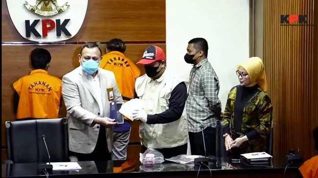Penyidik menunjukkan barang bukti berupa duit serta kamus bahasa Inggris yang telah dimodifikasi seperti boks dalam konferensi pers.