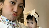 <p>Sering menemani Bunda bekerja, Nakeya terlihat modis mengenakan bando putih sambil di gendong Bunda Nola. Gemas banget ya, Bunda. (Foto: Instagram/riafinola)</p>
