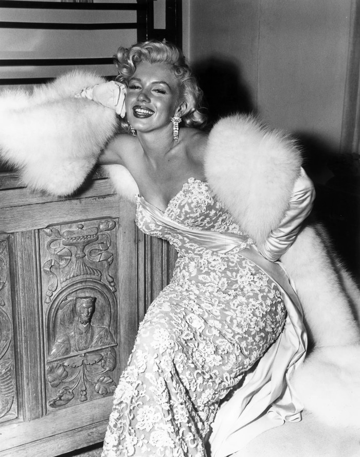 Hadir di premiere How To Marry A Millionaire tahun 1953, perempuan bernama asli Norma Jeane mengenakan gaun strapless karya William Travilla. French lace warna gading dan sequin melapisi kain nude pada dress. Foto: pinterest.com/Vogue Magazine