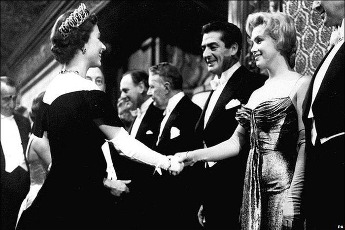 Marilyn Monroe bertemu Ratu Elizabeth II di tahun 1956 pada kesempatan screening film di London. Alih-alih pakai busana sopan sesuai peraturan, Monroe justru mengenakan slip dress emas lowcut nan seksi. Foto: instagram.com/marilynmonroecollection