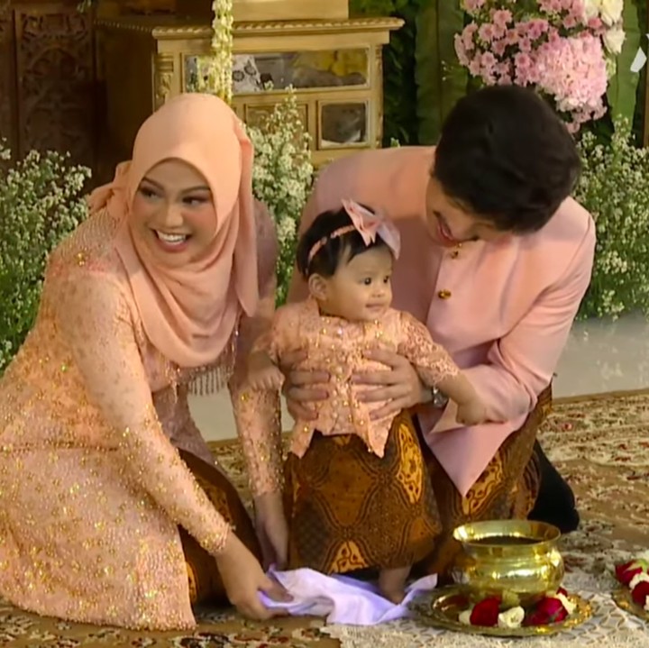 <p>Selanjutnya, Ameena melakukan prosesi injak tanah. Tradisi ini merupakan sebuah penghormatan kepada bumi di mana tempatnya belajar menginjakkan kaki. (Foto: YouTube AH)</p>