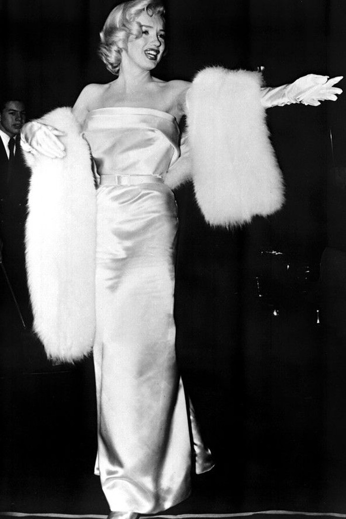 Serba putih, strapless silk dress dengan aksen ikat pinggang yang dikenakan Monroe ke premiere There’s No Business Like Show Business tahun 1954 tak bisa dilewatkan. Ia mengombinasikannya dengan fur shawl bernada senada. Foto: pinterest.com/British Vogue