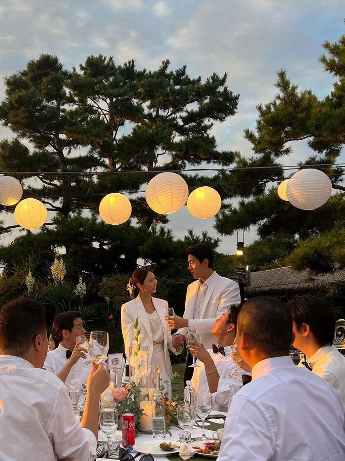 Usai mengikat janji, Lee Ki Woo bersama dengan istrinya tampak bahagia menjamu para tamu. Keduanya kompak menggunakan baju berwarna putih. Bahkan, Lee Ki Woo juga sempat bernyanyi bersama sahabatnya./ Foto: instagram.com/choon6