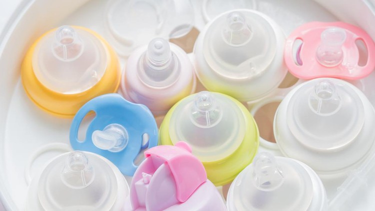 Ilustrasi Ukuran Dot Botol Susu Bayi Nipple teethers and milk bottles in steam sterilizer and dryer. Steam sterilizer used for sterilize baby accessories by high temperature steam.