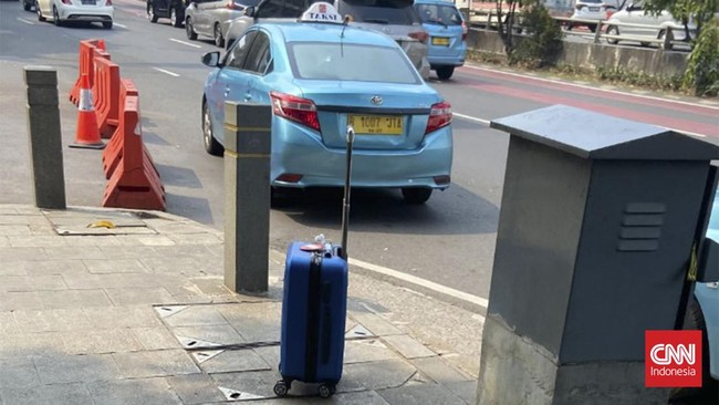 Sebuah koper biru tertinggal di trotoar depan Polda Metro Jaya, Jalan Gatot Subroto, Jakarta. Tak ada orang yang mengambilnya hingga Brimob turun tangan.