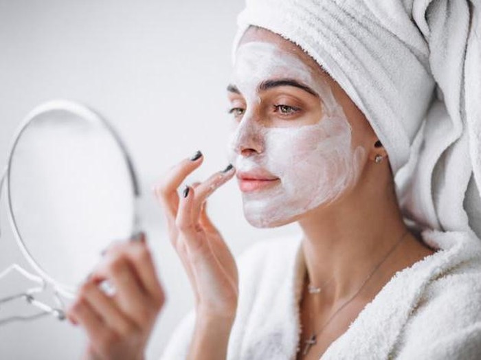 Perempuan menggunakan masker wajah