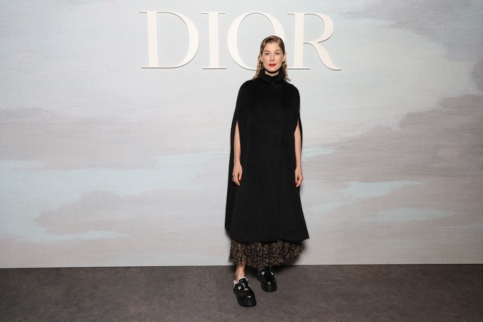 A casual touch is presented by Rosamund Pike who dares to combine a cape and a feminine skirt with clogs shoes.  Photo: Getty Images for Christian Dior/Pascal Le Segretain