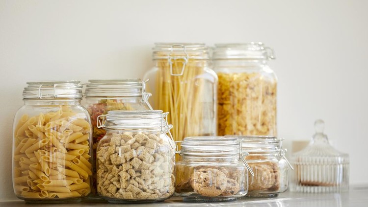 Close-up of food items in airtight jars. Fresh groceries are seen through glass containers. Eatables are on table.