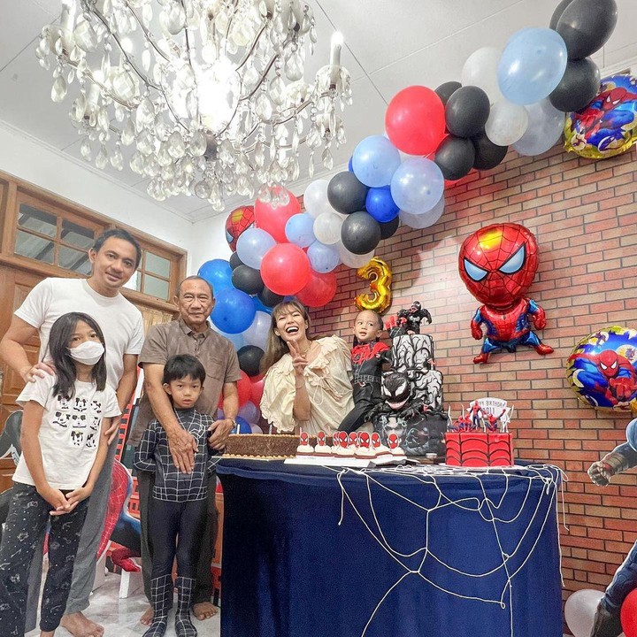 <p>Regi Datau, suami Ayu Dewi dan Ayah Ayu Dewi turut meramaikan perayaan ulang tahun baby Aqli. Regi nampak berpose di dekat mertua dan putri pertamanya, Aqila. (Foto: Instagram: @mrsayudewi)</p>