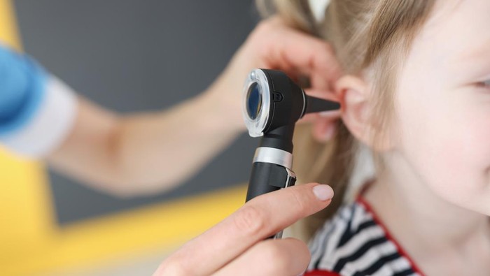 Doctor examines ear drum of little girl. Hearing impairment in children concept