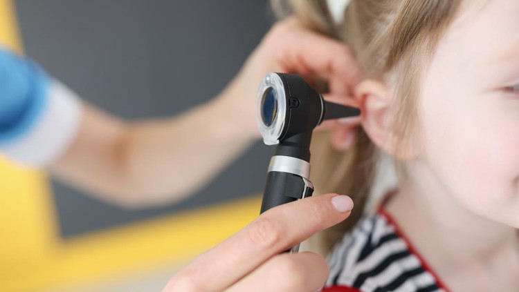 Doctor examines ear drum of little girl. Hearing impairment in children concept