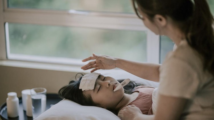 Ilustrasi Ciri Khas Demam Berdarah an asian chinese mother is taking care of her daughter on bed and measuring her body temperature with thermometer