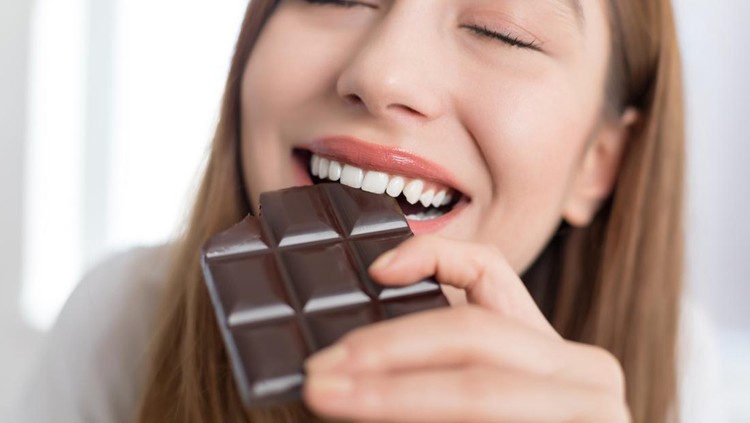 Woman biting a chocolate bar