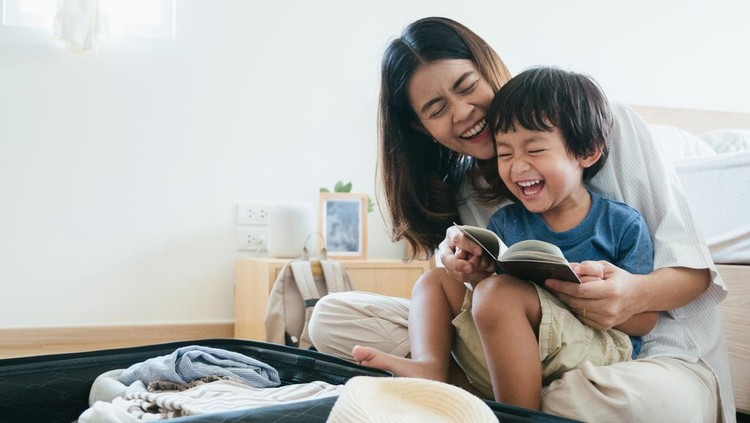 Young asian woman and little baby boy preparing for road trip at home.
