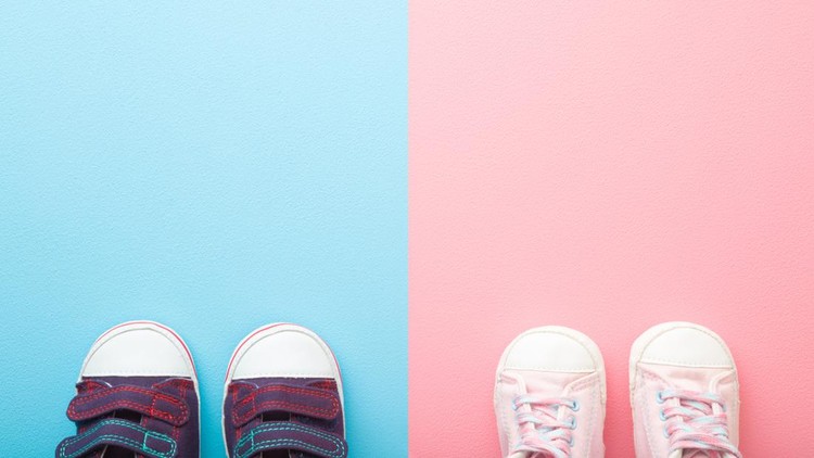 Two pairs of sport shoes for little boys and girls. Pastel blue pink background. Baby footwear. Empty place for text. Top down view.