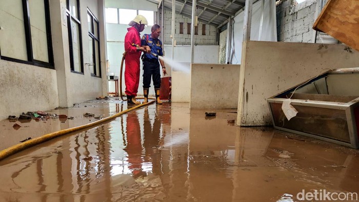 Petugas mulai membersihkan berbagai ruang di MTsN 19 Pondok Labu, Jakarta Selatan, Jumat (7/10). Ruangan itu terendam banjir pada Kamis sore kemarin.