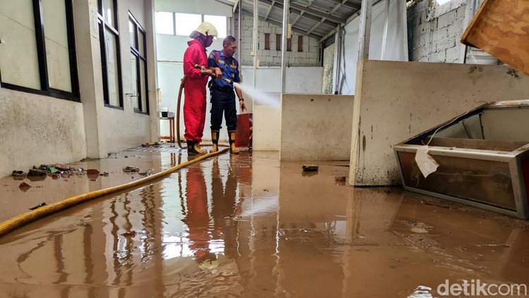 Petugas mulai membersihkan berbagai ruang di MTsN 19 Pondok Labu, Jakarta Selatan, Jumat (7/10). Ruangan itu terendam banjir pada Kamis sore kemarin.