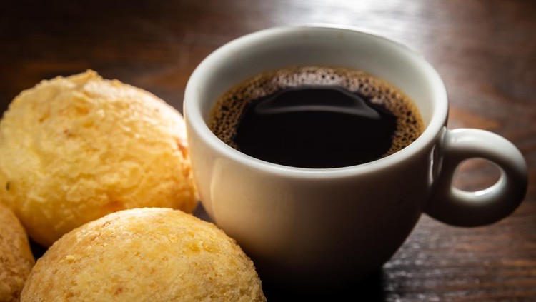 Ceramic cup with coffee and cheese breads.