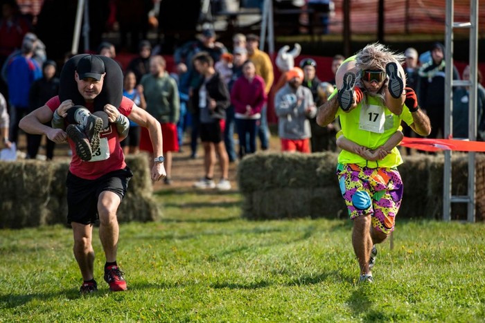 Two teams compete during the 23rd North American Wife Carrying Championship at Sunday River Resort in Newry, Maine, on October 8, 2022. (Photo by Joseph Prezioso / AFP) (Photo by JOSEPH PREZIOSO/AFP via Getty Images)