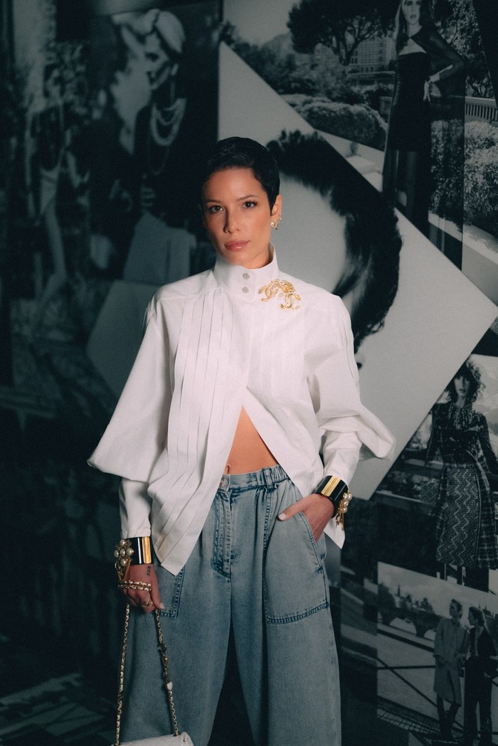 Bergaya feminin juga bisa ditampilkan dengan celana jeans lebar. Seperti dibuktikan penyanyi Halsey yang mengenakannya bersama blus putih. Foto: Courtesy of Chanel