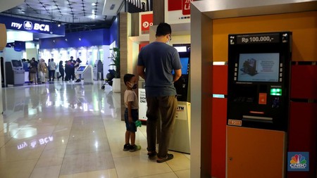 Warga melakukan transaksi di mesin ATM kawasan Kuningan, Jakarta, Selasa (11/10/2022). (CNBC Indonesia/Muhammad Sabki)