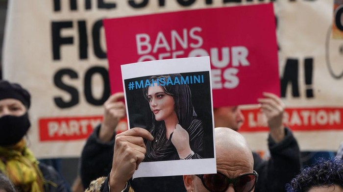 A demonstrator holds up a photo of Mahsa Amini during a rally to defend abortion access and codify Roe v Wade into law, in Foley Square in New York City on October 8, 2022. (Photo by Bryan R. Smith / AFP) (Photo by BRYAN R. SMITH/AFP via Getty Images)