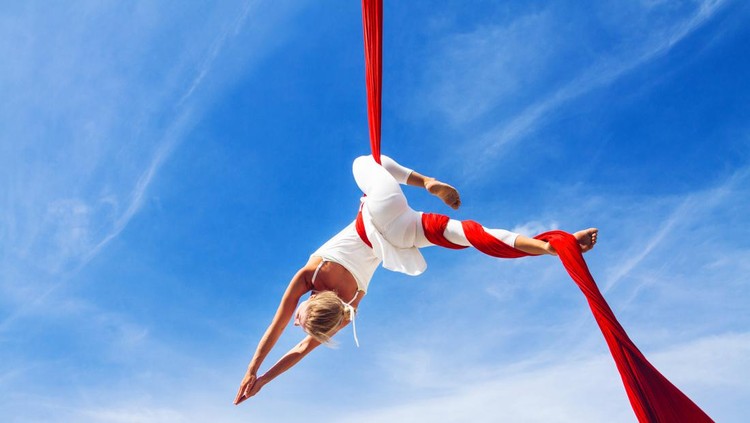 Aerial Yoga Woman practicing aerial silk yoga outdoors