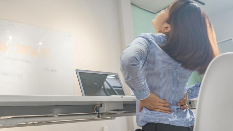 Woman stretch her back after sitting long time for working