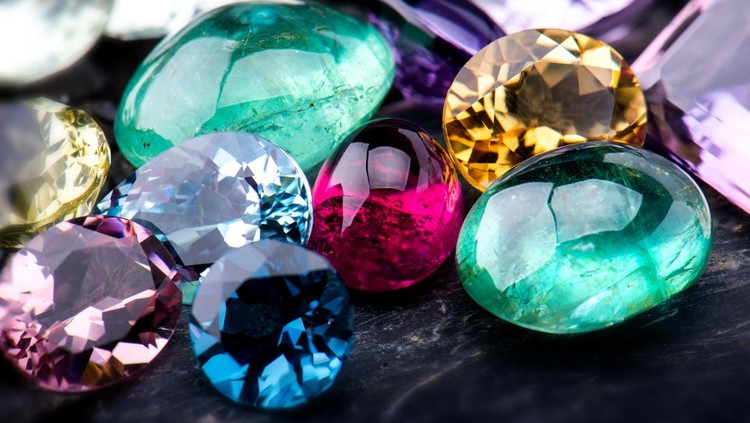 1067431158 Gemstones collection jewelry set photo with black stone and dark lighting.