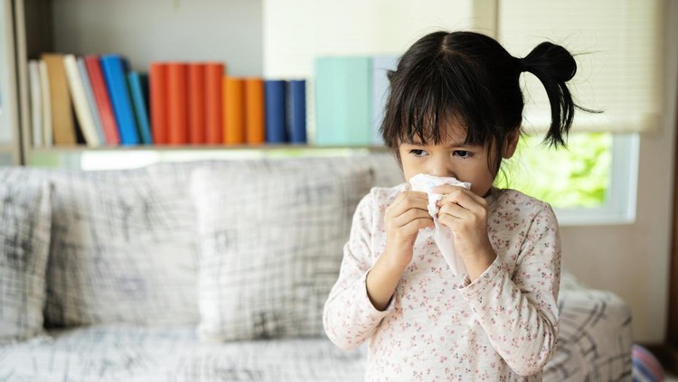 Runny nose. Sick little girl blowing her nose and covering it with handkerchief