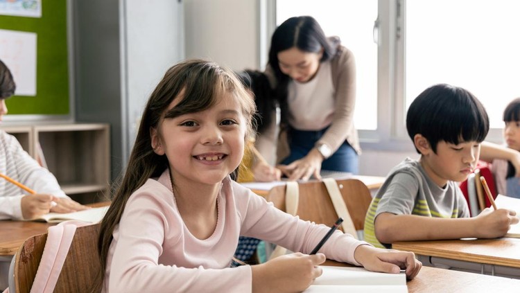 Portrait of Asian elementary school kids studying in a classroom. The girl smiled and looked at the camera. His classroom diversity