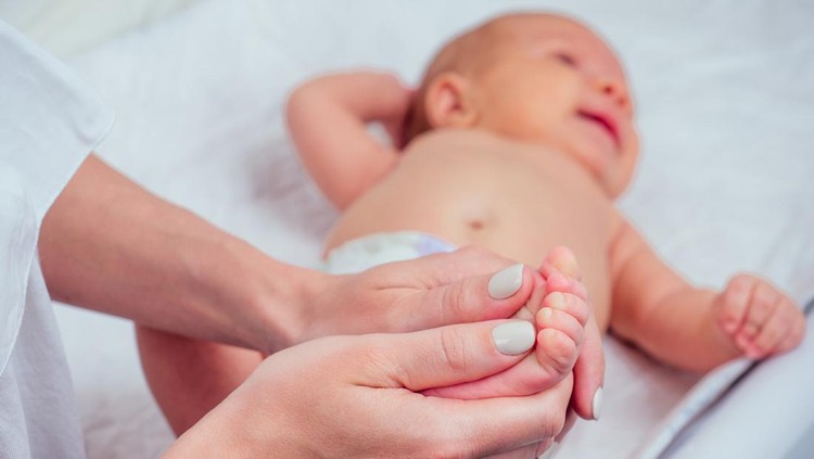 woman making foot massage to her little child close up .