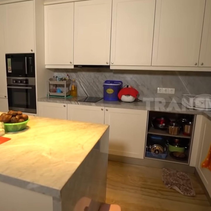 <p>Tema warna putih dan krem pun masih terlihat di dapur, lho Bun. Perabot dapur Bu Rudy pun lengkap mulai dari kompor induksi, microwave, oven, dan kulkas. (Foto: YouTube Trans 7)</p>