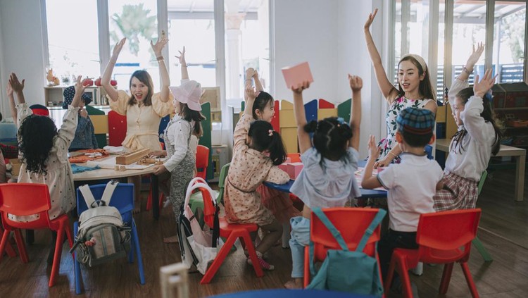 Ilustrasi Tempat Penitipan Anak atau Daycare Asian Montessori preschool student raised hands in the class answering question