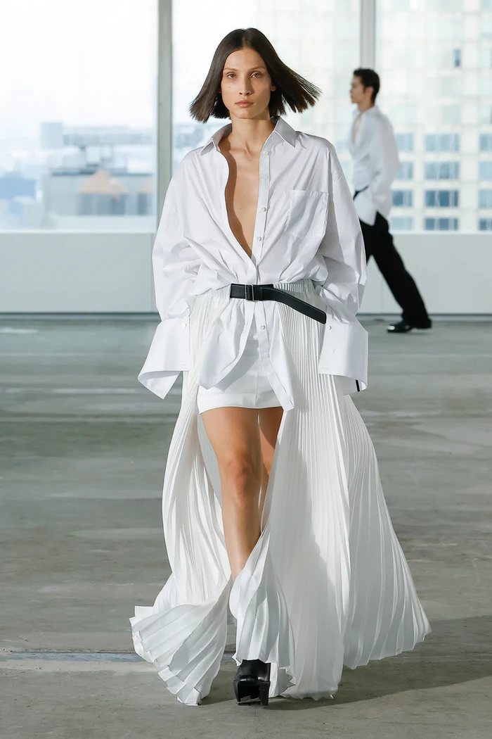 Desainer Peter Do menawarkan kemeja dengan model cuff atau pergelangan tangan yang besar dan dikenakan bersama rok asimetris detail lipit. Edgy dan minimalis! Foto: Courtesy of Peter Do