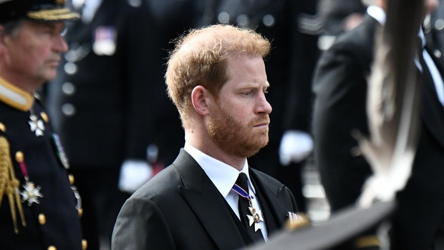 LONDON, ENGLAND - SEPTEMBER 19: Prince Harry, Duke of Sussex, follows the coffin of Queen Elizabeth II, draped in the Royal Standard, on the State Gun Carriage of the Royal Navy, as it travels from Westminster Abbey to Wellington Arch on September 19, 2022 in London, England. Elizabeth Alexandra Mary Windsor was born in Bruton Street, Mayfair, London on 21 April 1926. She married Prince Philip in 1947 and ascended the throne of the United Kingdom and Commonwealth on 6 February 1952 after the death of her Father, King George VI. Queen Elizabeth II died at Balmoral Castle in Scotland on September 8, 2022, and is succeeded by her eldest son, King Charles III.  (Photo by Stephane De Sakutin - WPA Pool/Getty Images)