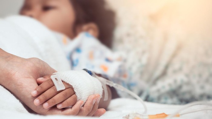 Mother hand holding child hand who have IV solution in the hospital with love and care