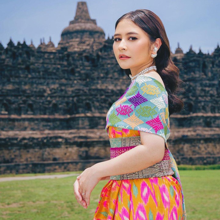 <p>Ia tampak menawan dengan balutan <em>dress</em> batik serta selendang kain berwarna cerah, Bunda. Penampilannya patut diacungi jempol, ya? (Foto: Instagram @prillylatuconsina96)    </p>
