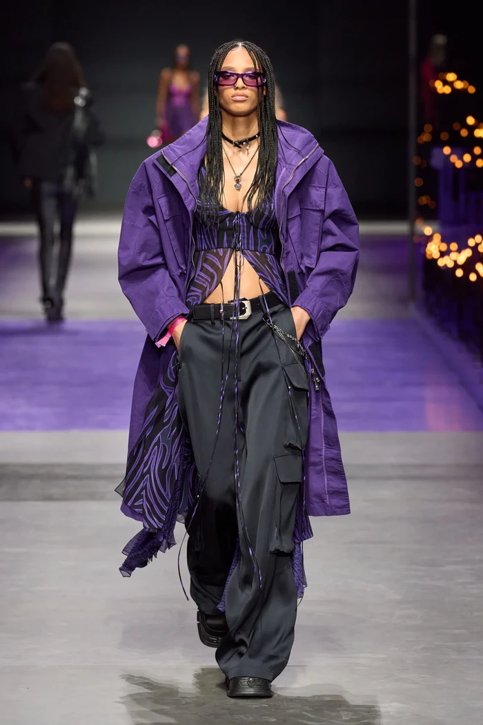 Versace membuatnya lebih sporty dengan padanan bralette, blus motif grafis dan jaket parka. Keep everything on the same color tones. Foto: Filippo Fior/Gorunway/Vogue