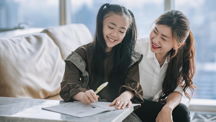 asian chinese young family mother daughter enjoying bonding time doing homework  at home during weekend in living room apartment