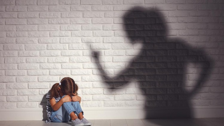 domestic violence. angry mother scolds   frightened daughter sitting on floor